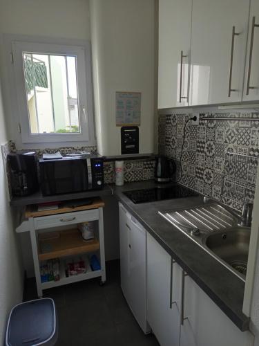 une cuisine avec un évier et un plan de travail dans l'établissement Studio terrasse calme à La Rochelle, à La Rochelle