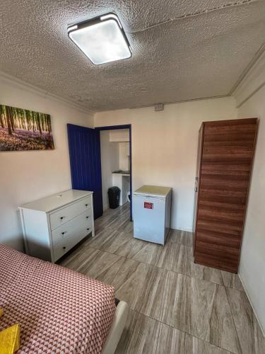 a bedroom with a bed and a dresser and a drawer at StudioOne Wembley in London