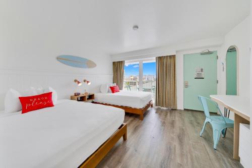a hotel room with two beds and a desk at Madison Resort Wildwood Crest in Wildwood Crest