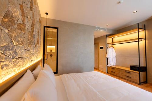 a bedroom with a large white bed and a mirror at Montis Agroturizëm Hotel Spa in Kaninë