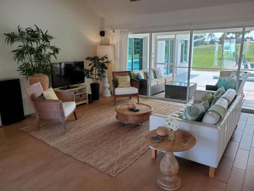 a living room with a white couch and chairs at Chasing Buoys at Swiss in Clermont