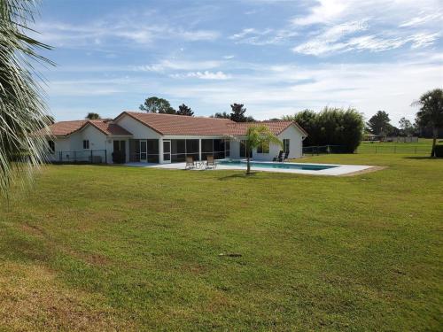 a house with a large yard with a pool at Chasing Buoys at Swiss in Clermont
