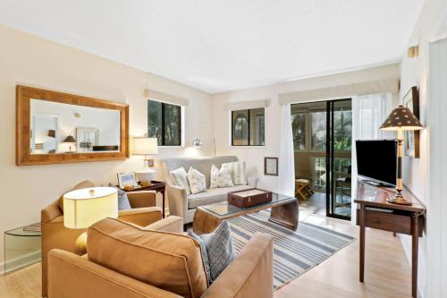 a living room with a couch and a tv at Coastal Calm Nature Retreat Villa on Port Royal Sound in Hilton Head Island