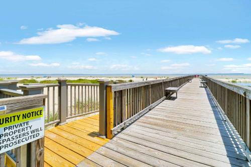 a wooden boardwalk leading to the beach with a sign at Coastal Calm Nature Retreat Villa on Port Royal Sound in Hilton Head Island