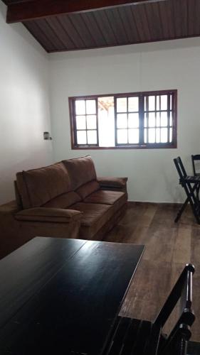 a living room with a couch and a table at Sua Praia seu lar in Itanhaém