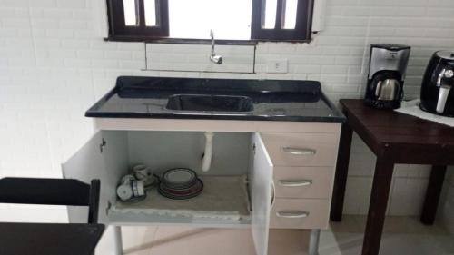 a kitchen with a sink and a counter top at Sua Praia seu lar in Itanhaém