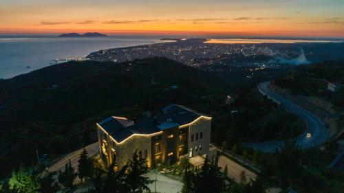 a building on top of a hill with a city at Montis Agroturizëm Hotel Spa in Kaninë