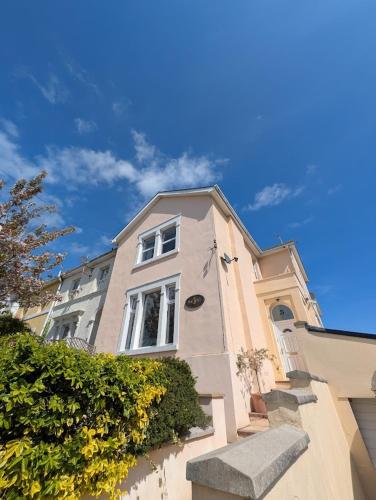 a building with a blue sky in the background at Garden studio near sea in Torquay