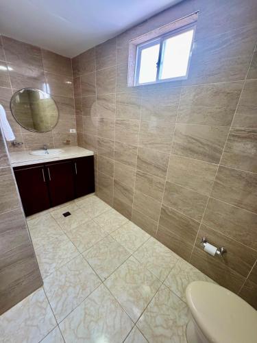 a bathroom with a toilet and a sink and a mirror at Hotel El Bosque Valledupar in Valledupar