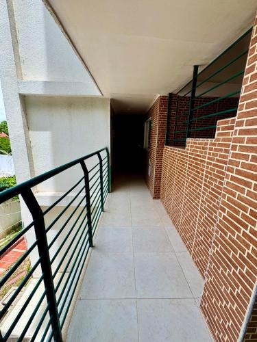 a hallway of a brick building with a black railing at Hotel El Bosque Valledupar in Valledupar