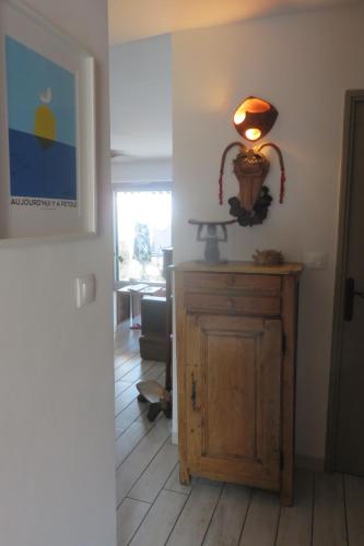 une lampe sur une armoire en bois dans un couloir dans l'établissement T2 50m carrés vue mer piscine tennis, à Hyères