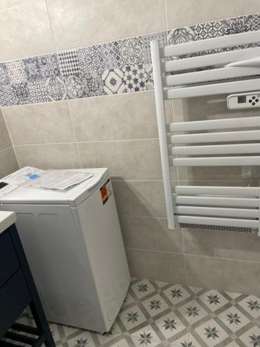 une salle de bain avec toilettes et un mur carrelé dans l'établissement Location appartement au lavandou, au Lavandou
