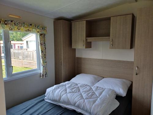 un lit dans une petite pièce avec une fenêtre dans l'établissement Glenan01, à Clohars-Carnoët