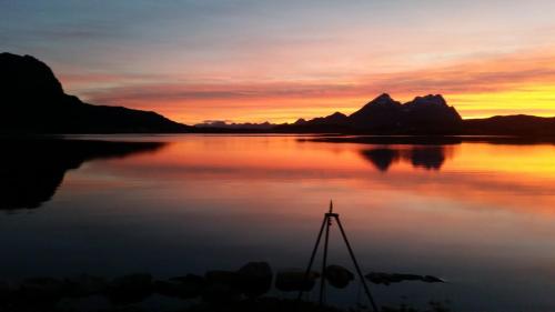 a sunset over a large body of water at Amazing Sea House in magic Lofoten in Vestvågøya