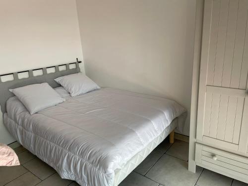 - un lit blanc avec deux oreillers dans l'établissement Location appartement au lavandou, au Lavandou