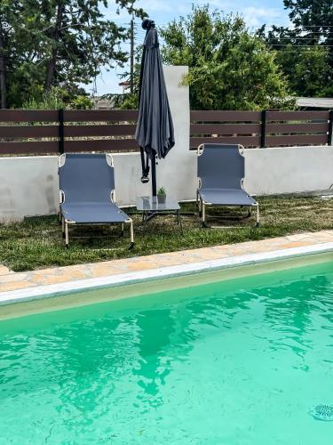 two chairs and an umbrella next to a swimming pool at Piscina Mare #PROPERTLY in Nea Kallikrateia