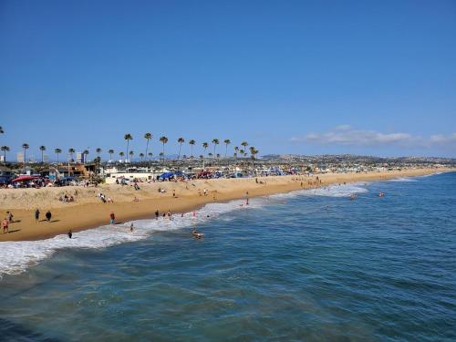 a group of people on a beach with palm trees at Charming 2Br Condo W Ac Steps To Beach & Balboa Pier By Beachview Rentals in Newport Beach