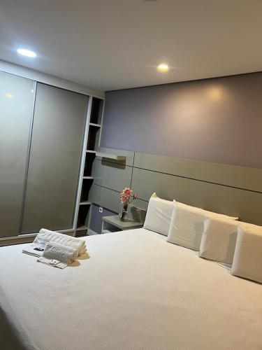 a bedroom with a large bed with white sheets and pillows at Hotel Oceania in Eunápolis