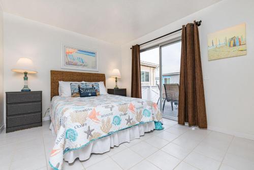 a bedroom with a bed and a balcony at Spacious 4Br W Oceanview Balcony & Bbq Steps To Sand By Beachview Rentals in Newport Beach