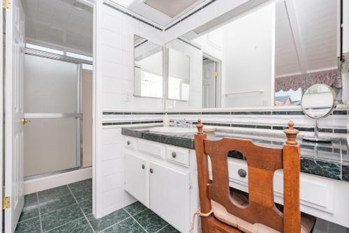 a white bathroom with a sink and a mirror at 7Br Beachfront Retreatstunning Ocean Views & Walkable Fun By Beachview Rentals in Newport Beach