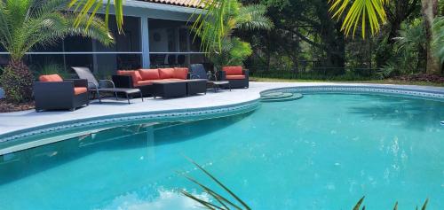 a large swimming pool with chairs and chairs in front of a house at Sunset Cove in Clermont