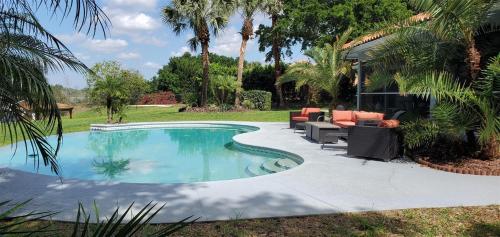 a swimming pool in a yard with palm trees at Sunset Cove in Clermont