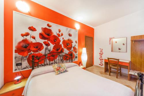 a bedroom with a bed with red flowers on the wall at Oasi Verde in Castiglione Chiavarese