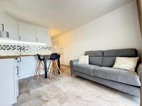 un salon avec un canapé et une cuisine dans l'établissement Appartement avec vue sur mer, au Barcarès