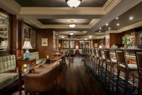 a bar with leather chairs and tables in a restaurant at JW Marriott Marquis City Center Doha in Doha
