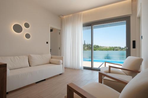 a living room with a white couch and a large window at Anapnoe ikies Corfu Adults Friendly in Sfakerá