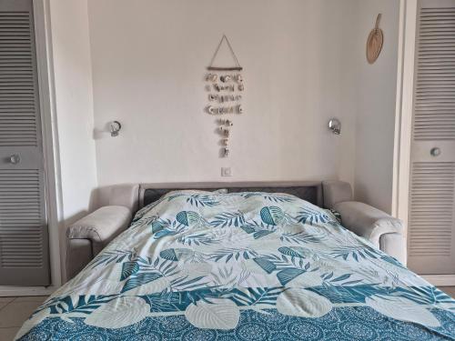 - un lit avec une couette bleue et blanche dans une chambre dans l'établissement Charmant Mazet à 250m de la Plage San Peire aux Issambres, à Saint-Peïre-sur-Mer