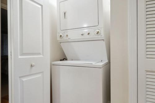 a white washer and dryer with a microwave above it at Soundfront Stay Beach Pools & More at The Spa in Hilton Head Island