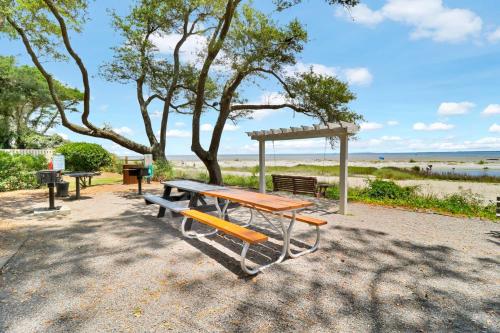 a picnic table and benches in front of the beach at Soundfront Stay Beach Pools & More at The Spa in Hilton Head Island