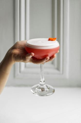 a person holding a red and white dessert in a glass at The Shelbourne, Autograph Collection in Dublin