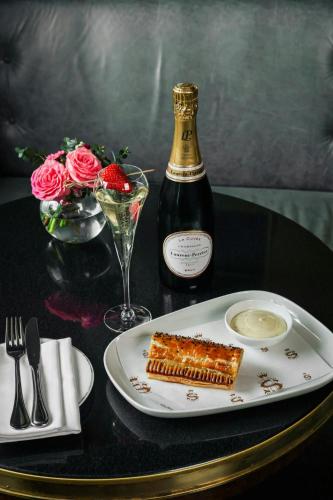 a table with a plate of food and a bottle of wine at The Shelbourne, Autograph Collection in Dublin
