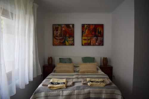 a bedroom with a bed with three pictures on the wall at Villa Pannonia in Pannonhalma