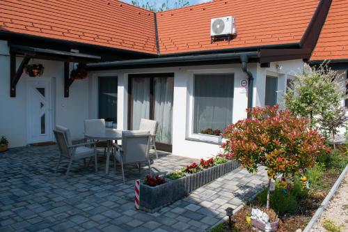 a patio with a table and chairs and a house at Villa Pannonia in Pannonhalma