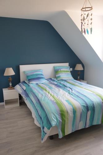 une chambre avec un lit avec un mur bleu dans l'établissement Maison familiale avec jardin à 2 pas de la mer, à Perros-Guirec