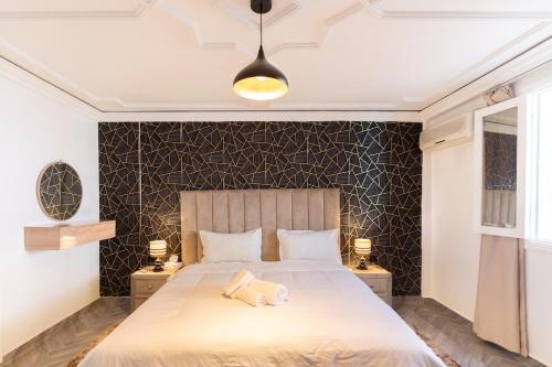 a bedroom with a large bed and two night stands at Maison soleil - Appartement pour famille in Marrakech