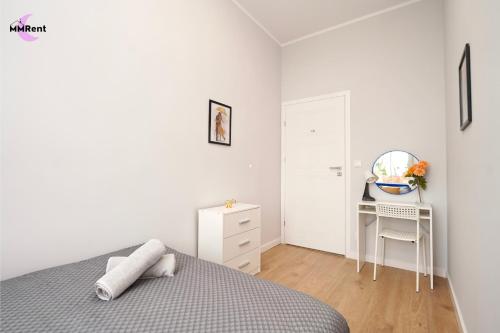 une chambre blanche avec un lit et un bureau dans l'établissement MMRent Umbrella Room, à Gdańsk