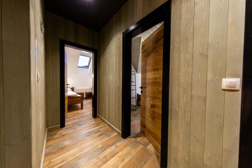 a hallway with wooden walls and two open doors at Mariska Villa in Izvoru Mureşului