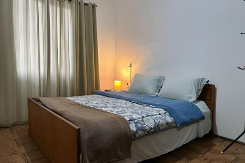 a bedroom with a bed with a blue blanket at Large apartment in the center in Pomerode