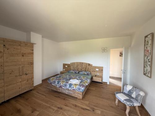 a bedroom with a bed and a chair in it at Appartamenti Ai 7 nani in Peron