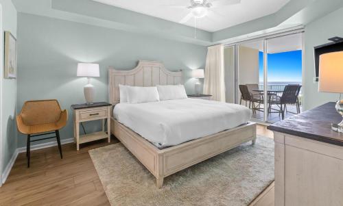 a bedroom with a bed and a table with a chair at The Crescent 306 in Destin