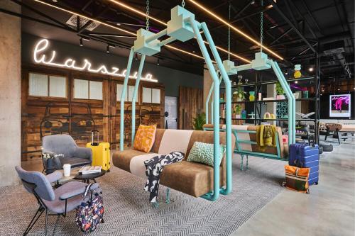 a showroom with a couch and chairs and a sign at Moxy Warsaw City in Warsaw
