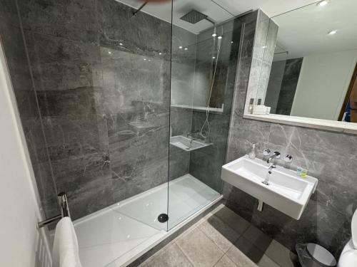 a bathroom with a shower and a sink and a tub at 5 Brewhouse by Pureserviced in Plymouth