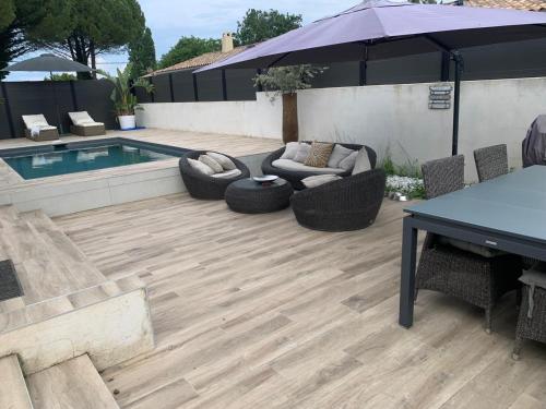 un patio avec une table et des chaises et une piscine dans l'établissement Maison agréable pour vacances réussies, à Vernègues