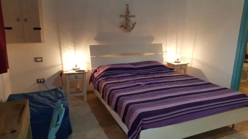 a bedroom with a bed with two lights on it at Casolare La Torre in Scopello