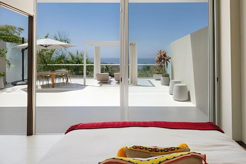 a bedroom with a view of the ocean from a balcony at Bolongo in Higuera Blanca