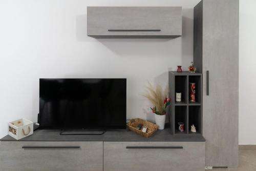 una TV a schermo piatto posizionata sopra un centro di intrattenimento di El raposso a Chioggia